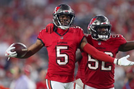 American football player intercepts a pass and celebrates with his team player