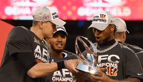 American football players celebrate after winning a trophy