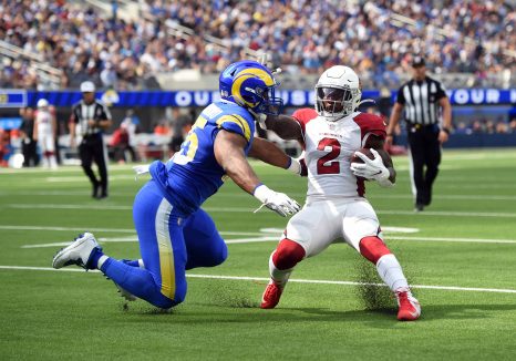 American football player pushes away from an opposite player during a match