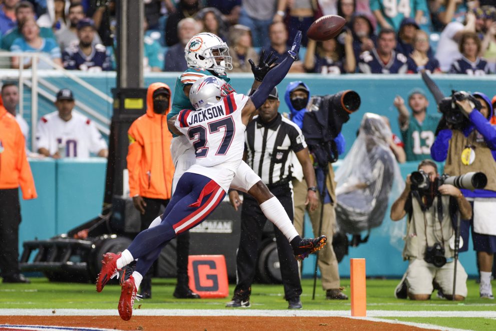 American football player defends a pass thrown to a wide receiver during the game