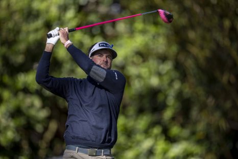 Golf player plays a tee shot on a hole during golf game