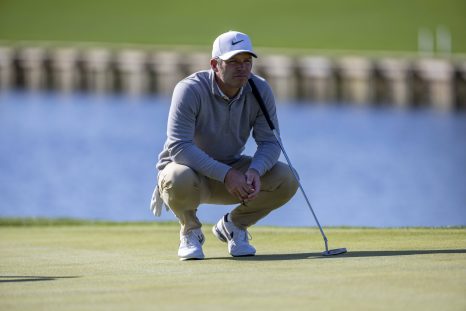 Golf player looks on after kicking the ball