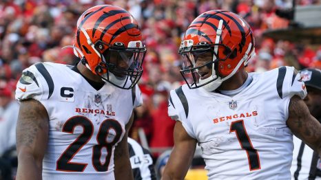 Two american football players talk on the field during a match